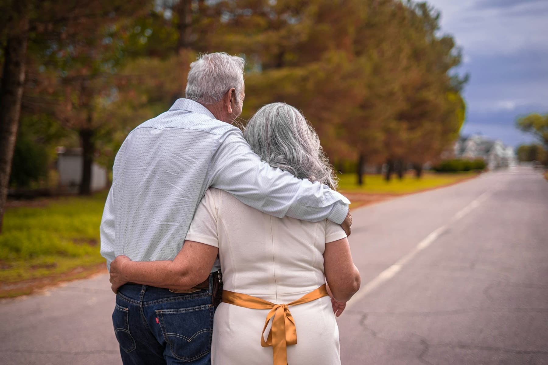 Ouder echtpaar loopt arm in arm over een rustige laan